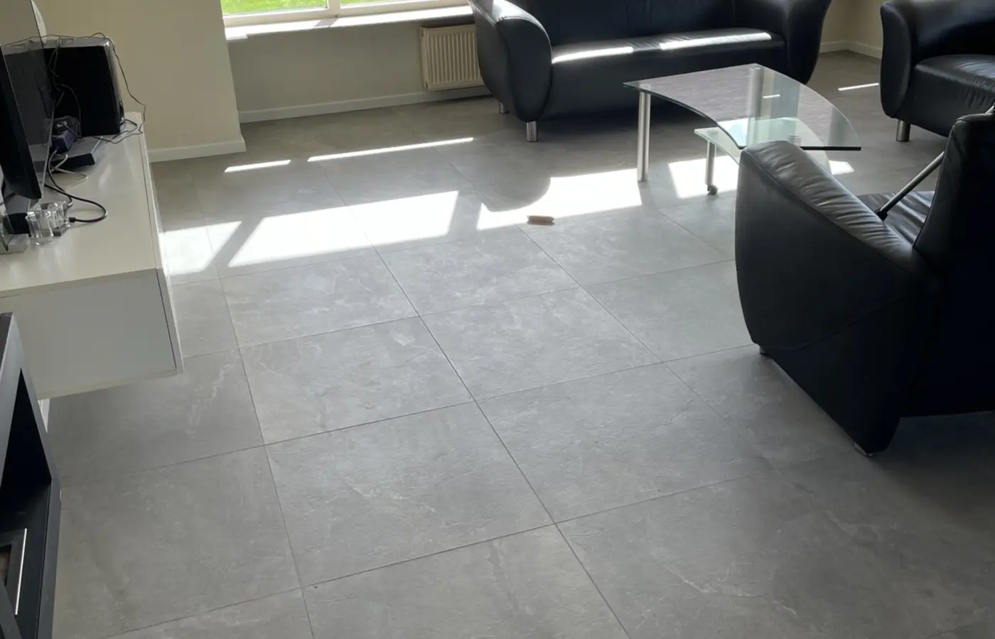 Afgewerkte grijze tegelvloer in de woonkamer
